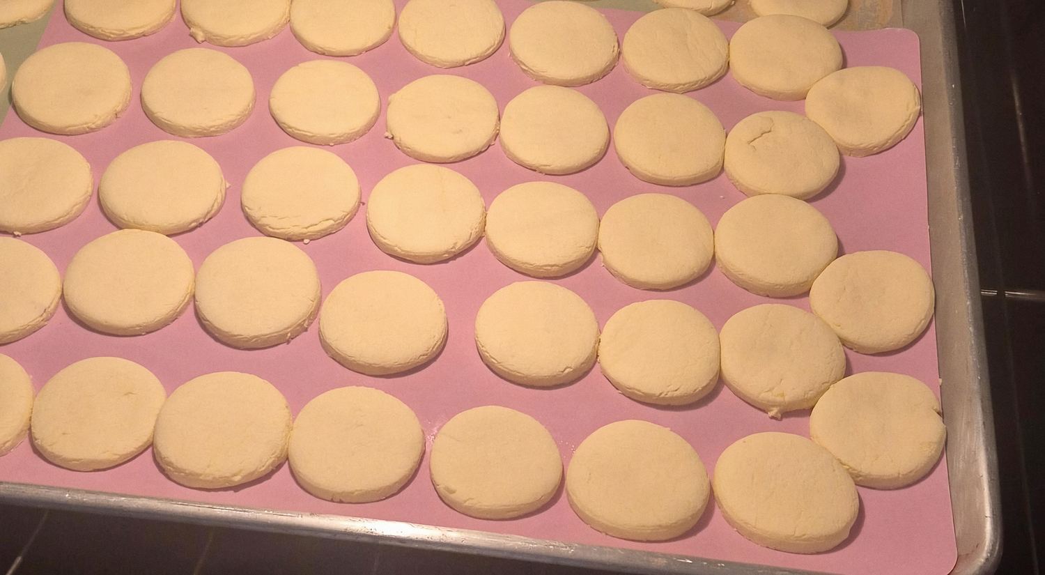 Galletas recién horneadas sobre un tapete rosa en la charola