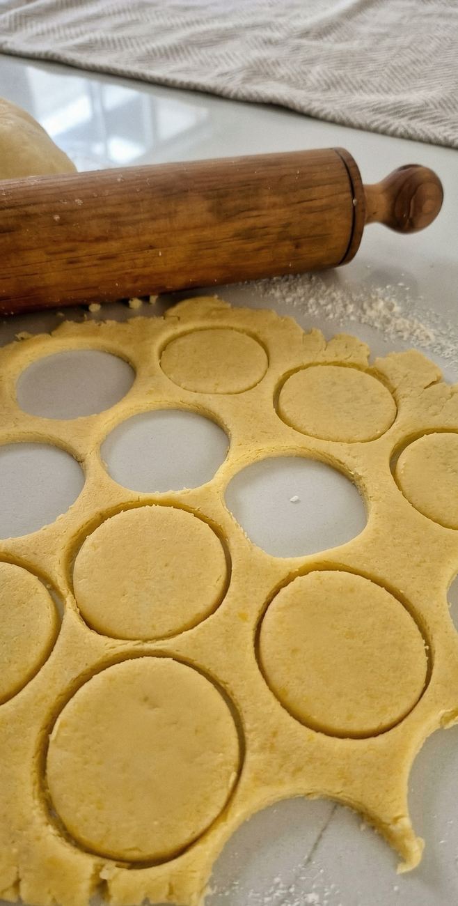 Masa extendida con rodillo de madera y círculos cortados