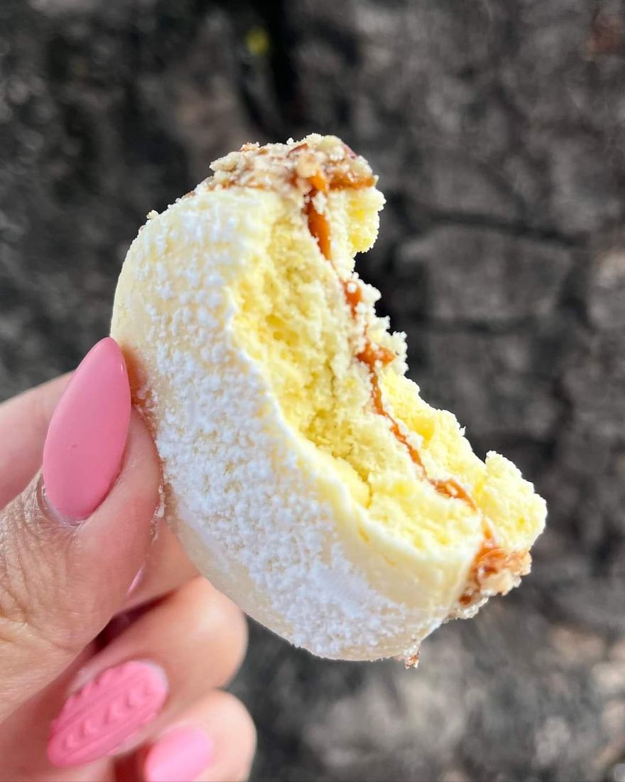 Alfajor de nuez mordido, con el dulce de leche a la vista